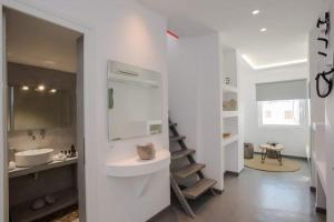 a white bathroom with a sink and a mirror at Jonaz Rooms & Suites in Mikonos +26 photos