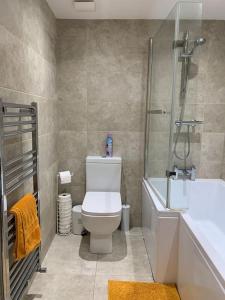 a bathroom with a toilet and a shower and a sink at Fantastic 1 Bedroom Basement flat with free parking in Sale