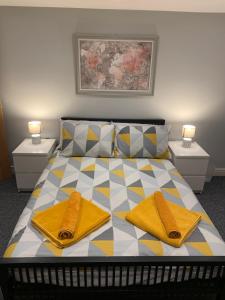 Fantastic 1 Bedroom Basement flat with free parking في سال: غرفة نوم عليها سرير وفوط صفراء