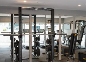 einen Fitnessraum mit mehreren Laufbändern und Spiegeln in der Unterkunft The Porter House Hotel Sydney - MGallery in Sydney