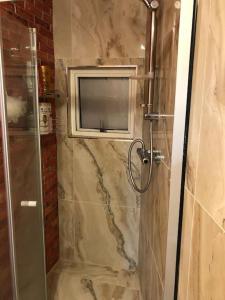 a bathroom with a shower with a television on the wall at Cheerful 4 bedroom house with garden free parking in London