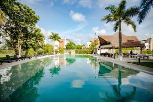 una piscina con palme e un edificio di Exclusive building 6 people 3 cable televisions 3 swimming pools balcony, a Cancún