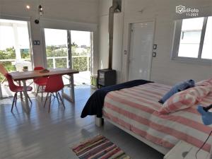 1 dormitorio con cama, escritorio y mesa en Ukukus, en Punta del Diablo