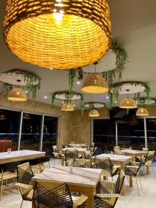 a restaurant with tables and chairs and a large chandelier at HOTEL PROVINCIA PLAZA in San Juan del Cesar