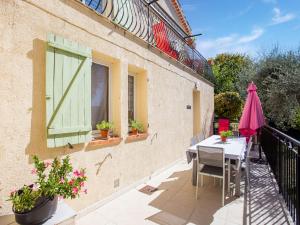 un patio con mesa y sombrilla en Cosy vacation home with terrace, en Berre-des-Alpes
