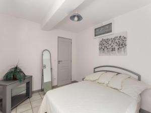 Habitación blanca con cama y espejo en Cosy vacation home with terrace, en Berre-des-Alpes