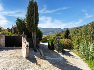 una entrada con una valla y un árbol en una colina en Cosy vacation home with terrace, en Berre-des-Alpes