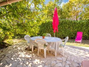 ベール・レ・ザルプにあるHoliday home with terrace in Berre les Alpesのテーブル、椅子、赤い傘