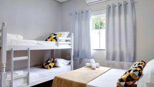 Un dormitorio con dos literas y una ventana. en Linda Casa próxima Cataratas/Aeroporto/wifi/garagem, en Foz do Iguaçu