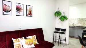 sala de estar con sofá rojo y taburetes en Linda Casa próxima Cataratas/Aeroporto/wifi/garagem, en Foz do Iguaçu