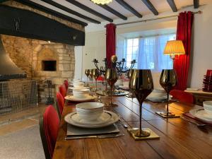 una sala da pranzo con un lungo tavolo in legno con sedie rosse di 6 Bedroom Farm House with 12 Beds in Weldon a Weldon