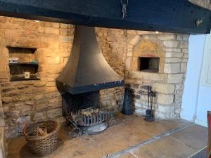 chimenea de piedra con estufa en la habitación en 6 Bedroom Farm House with 12 Beds in Weldon en Weldon