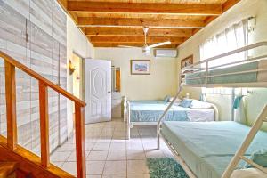 a room with two bunk beds and a staircase at Villa con Piscina-BBQ-Gazebo-Fogata-Hamacas in Básima