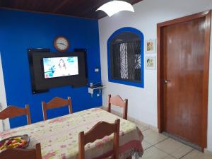 クイアバにあるHostel Aconchego do Lar - CPA 1の青い壁にテレビとベッドが備わるベッドルーム1室が備わります。