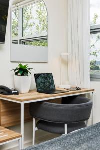 a desk with a chair and a laptop on it at Quest Mawson Lakes in Adelaide