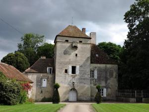 um antigo edifício de pedra com uma torre num campo em Gîte Treteau, 2 pièces, 2 personnes - FR-1-489-64 em Tréteau