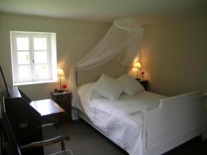 um quarto com uma cama branca e uma janela em Gîte Treteau, 2 pièces, 2 personnes - FR-1-489-64 em Tréteau