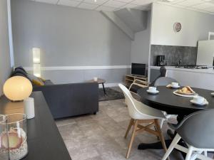 a living room with a table and a person sitting at a table at Maison rénovée avec jardin, BBQ, animaux acceptés - FR-1-489-341 in La Chabanne +9 photos