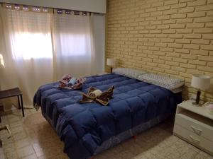 a large blue bed in a room with a brick wall at Angeles del Limay in Cipolletti