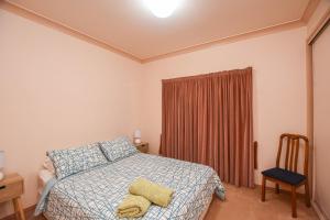 sypialnia z łóżkiem z żółtym ręcznikiem w obiekcie Karinya Cottage w mieście Myrtleford