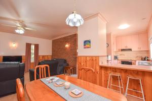 kuchnia i salon ze stołem i krzesłami w obiekcie Karinya Cottage w mieście Myrtleford