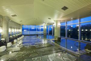 a large room with a swimming pool in a building at KAMENOI HOTEL Fukui in Fukui
