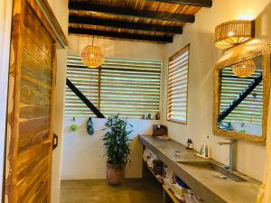 a bathroom with a sink and two windows at NOSOTROS Playa Maderas - Surf House & Casitas in Playa Maderas