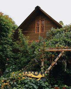 a wooden house with a garden in front of it at Cabañas Sinduly Bed & Breakfast in Sopó