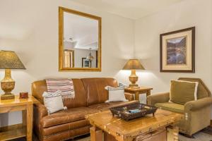 a living room with a brown leather couch and a table at Blue Collar Boutique: Affordable Adventure in Telluride