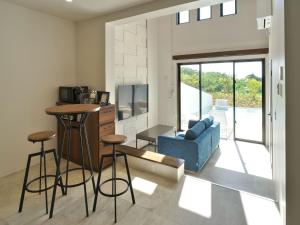 un soggiorno con bar e divano blu di ADANRESORT LANA Villa Suite a Motobu