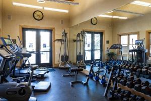 a gym with exercise equipment and clocks on the wall at Blue Collar Boutique: Affordable Adventure in Telluride
