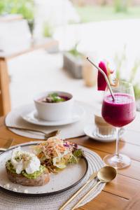 einen Tisch mit einem Teller Essen und einem Getränk in der Unterkunft Origin Lombok in Kuta Lombok