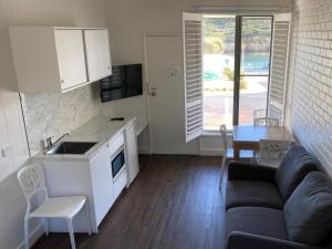 a kitchen and living room with a couch and a table at Southern Ocean Motor Inn in Port Campbell
