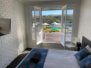 a bedroom with a bed and a large window at Southern Ocean Motor Inn in Port Campbell
