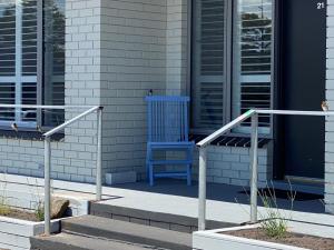 a blue chair sitting on the side of a building at Southern Ocean Motor Inn in Port Campbell