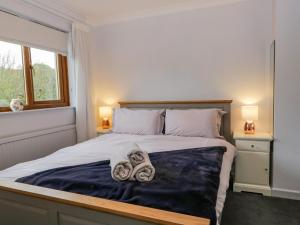 a bedroom with a bed with towels on it at Ravenglass Retreat in Ravenglass