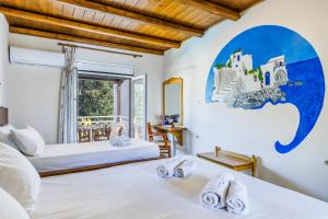 1 dormitorio con 2 camas y ventana en Ionia Hotel en Skopelos Town