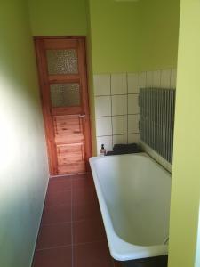 a bath tub in a bathroom with a door at Naktsmājas Jaunlaicenē in Jaunlaicene