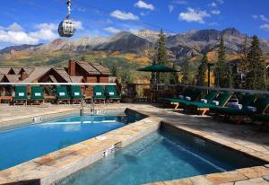einen Pool mit Stühlen und einem Berg in der Unterkunft Blue Collar Boutique: Affordable Adventure in Telluride