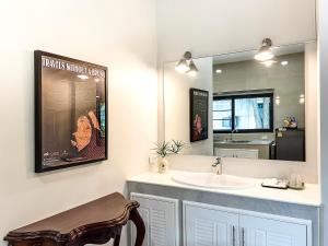 a bathroom with a sink and a mirror at Chez Bure - Bure Homestay in Kanchanaburi