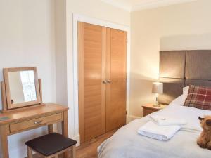 a bedroom with a bed with a desk and a mirror at Dairy Cottage - Uk39522 in Maybole