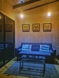 Una sala de estar con un sofá azul y una mesa de café. en Loft Puro Ranco, en Lago Ranco