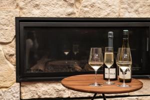 dos copas de vino en una mesa frente a una chimenea en The Henty, en Mount Gambier