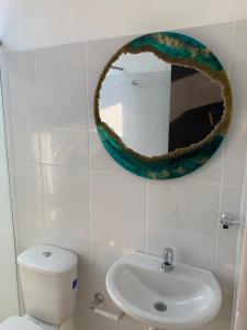 La Paloma Glamping في Palestina: حمام مع حوض ومرآة على الحائط