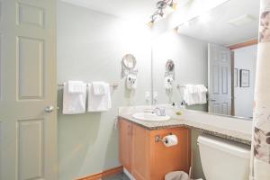 ein Bad mit einem Waschbecken und einem Spiegel in der Unterkunft The best ski in ski out two bedroom condo at Aspens in Whistler