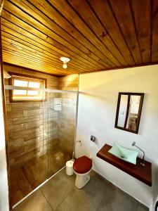 a bathroom with a shower and a toilet and a sink at Bella Vista Kitnets in Farol de Santa Marta