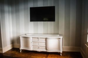 a white dresser with a television on a wall at Haus Zauberflöte in Offenburg