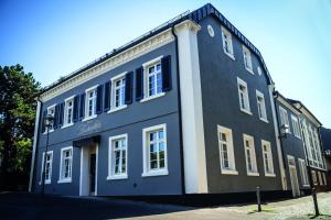 niebieski budynek z białymi oknami na ulicy w obiekcie Haus Zauberflöte w mieście Offenburg