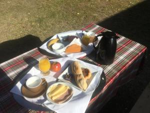 a picnic table with a plate of food and drinks at Posada Tanti El Durazno in Tanti