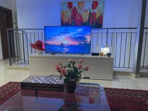 uma sala de estar com televisão e um vaso com flores em Gorgeous duplex in heart of Jerusalem em Jerusalém